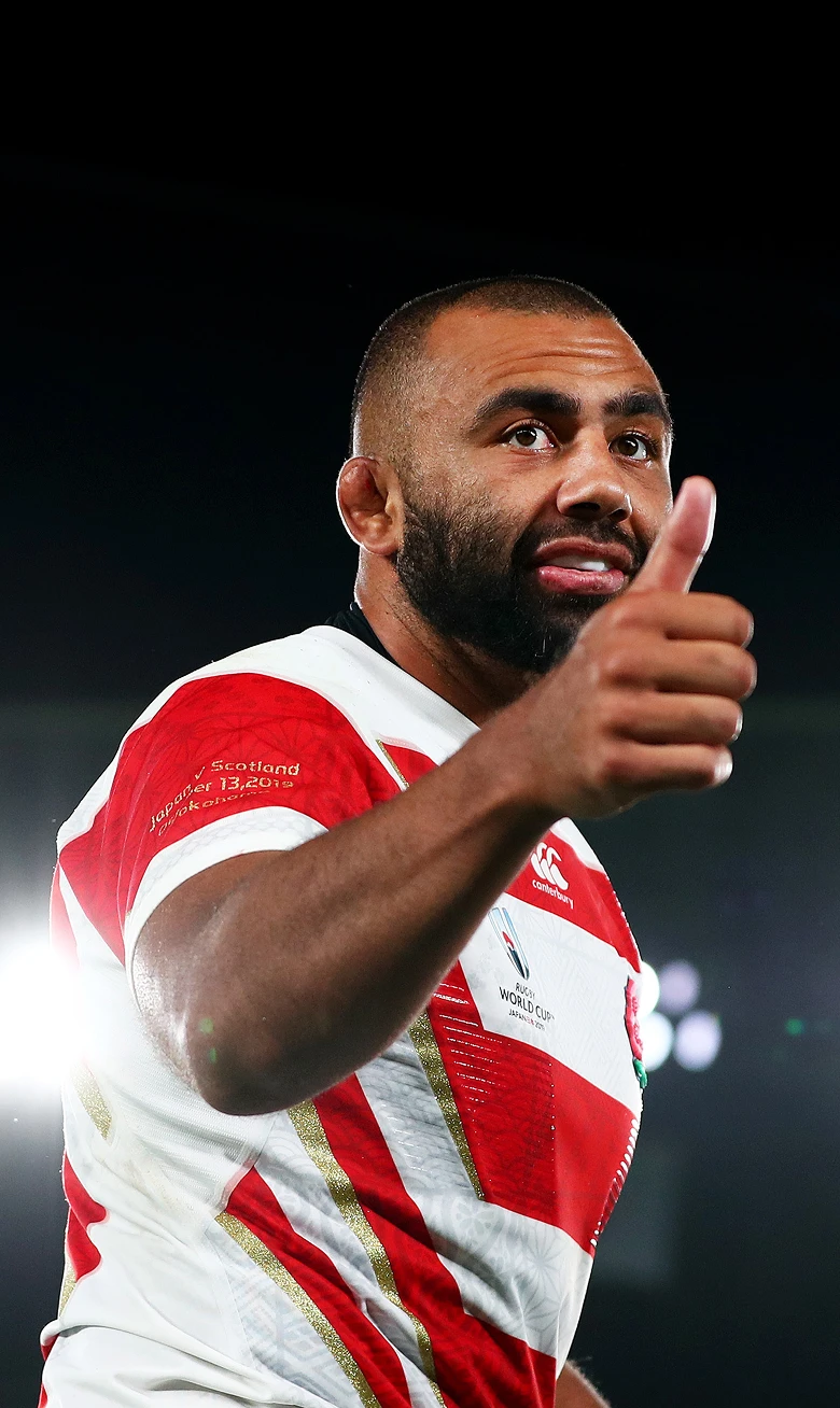 ラグビー選手のリーチ マイケルが、親指を立てて笑顔を見せている。